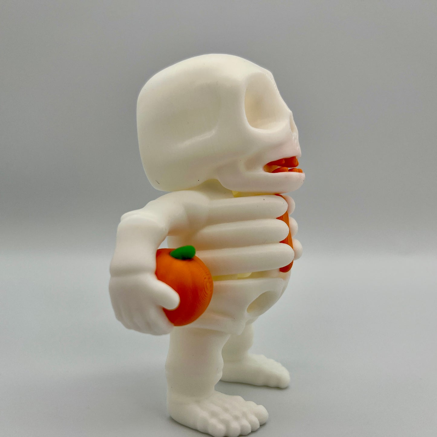 Skeleton Holding Pumpkin — Matte Ivory White 4"