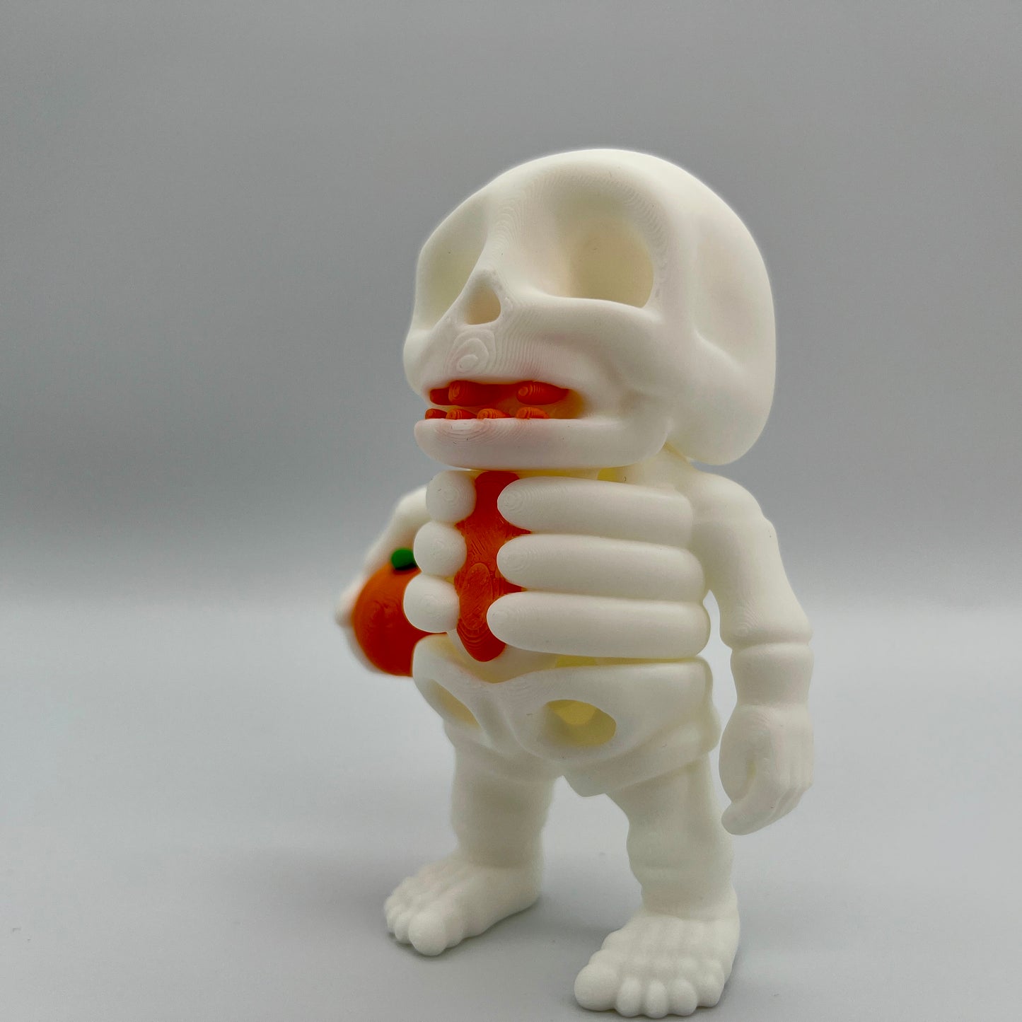 Skeleton Holding Pumpkin — Matte Ivory White 4"