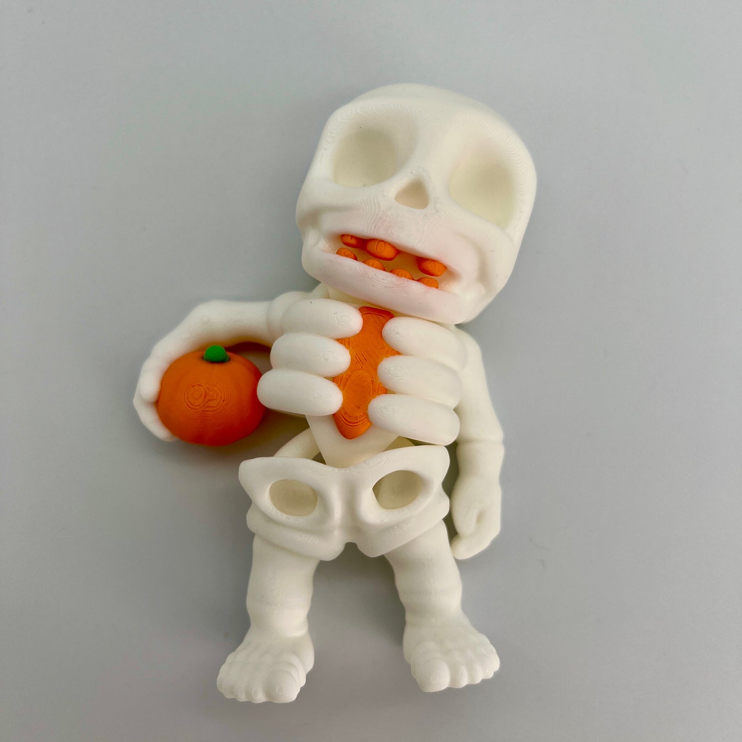 Skeleton Holding Pumpkin — Matte Ivory White 4"