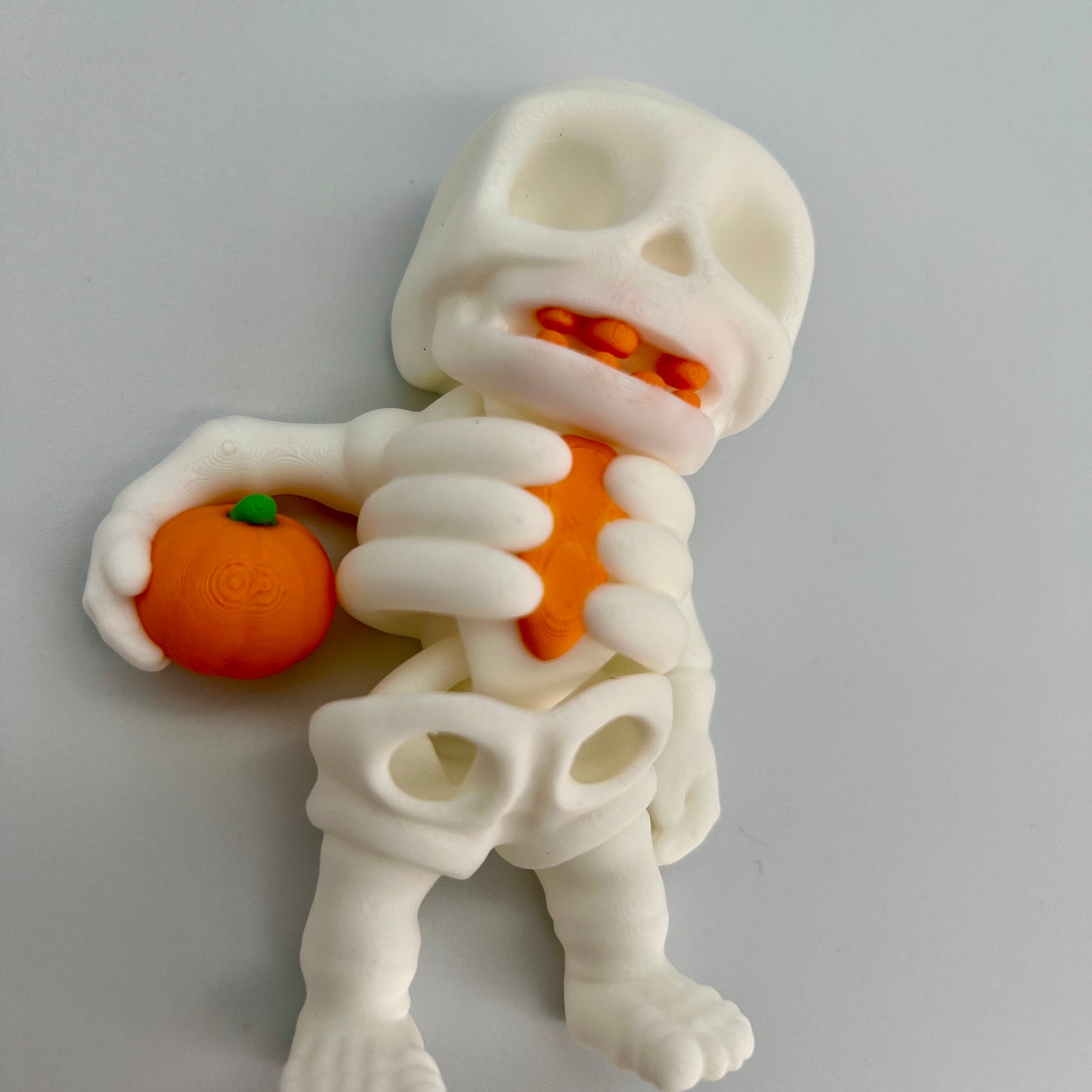 Skeleton Holding Pumpkin — Matte Ivory White 4"