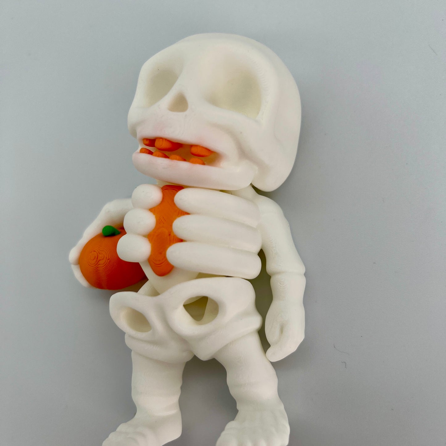 Skeleton Holding Pumpkin — Matte Ivory White 4"